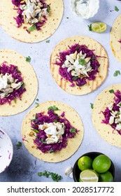 Fish Tacos From Sea Bass Garnished With Red Cabbage And Mexican Crema Top View With Fresh Lime And Cilantro Garnish On Flour Tortilla