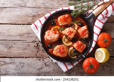 Fish In Tomato Sauce With Olives And Lemon In A Frying Pan. Horizontal View From Above
