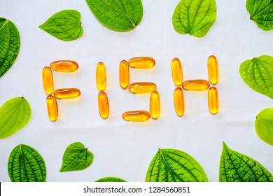 Fish Word Written  With Omega 3 Pills. Omega 3 Fish Oil Pills With Green Leaf.