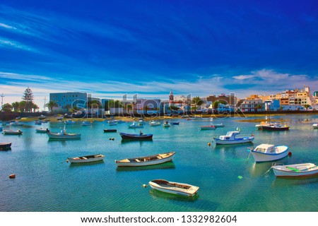 Fisher boats at the laguna Charco de San Gines and the tower of the historic church Iglesia de San Gines at sunshine, city of Arrecife, Lanzarote, Canary Islands Foto stock © 