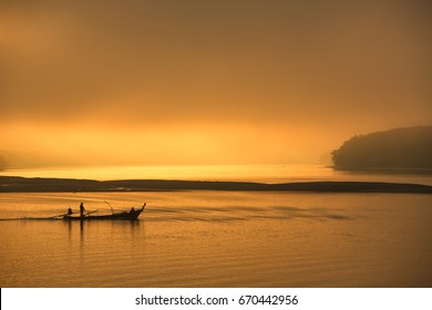 Fisherman in a boat on the river at beautiful sunrise