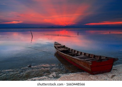 A fisherman boat parking at beach during sunset. - Powered by Shutterstock