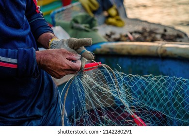 Fisherman casting his net at the sunrise or sunset. Traditional fishermen prepare the fishing net