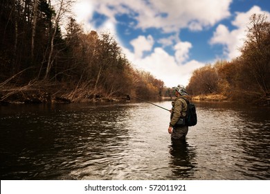 Fisherman catches a trout on the river in autumn - Powered by Shutterstock