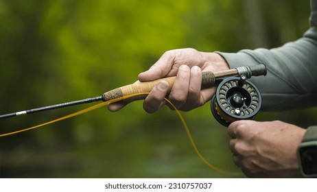 Fisherman catching brown trout on the fly standing in river. Close up. - Powered by Shutterstock