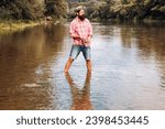 Fisherman caught a fish. Man fishing on river. Mature man fishing. Fisherman throws a spinning from shoreside. Positive male angling at river, rotating reel rod. Fisher enjoying his weekend.