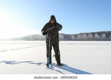 A Fisherman Drills A Hole In The Ice To Catch Fish