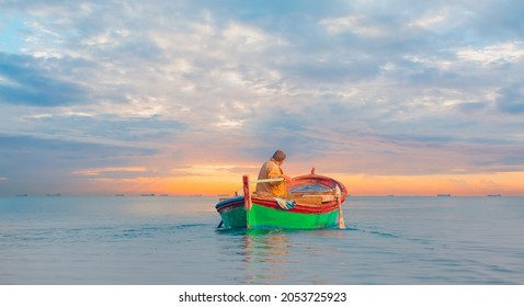 Fisherman With Fishing Boat In A Calm Sea In The Background Amazing Sunset