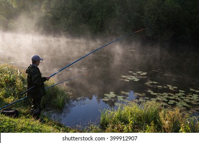 Fisherman With A Fishing Pole At Sunrise On The Lake