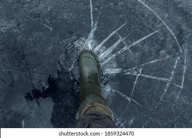 Fisherman Foot On Broken Cracked Thin Ice At Lake. Dangerous Fishing