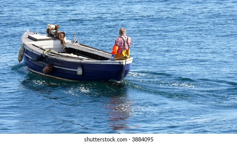 A fisherman going out on his small boat to lift the lobster/crab pots (creels).