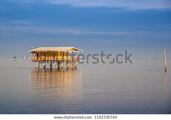 Fisherman house on the calm lake .Stilt houses\
built on the sea in\
Thailand