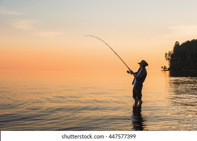 Fisherman at lake on sunset
