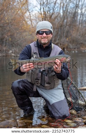 fisherman with a large steelhead caught in the Boise River, Idaho