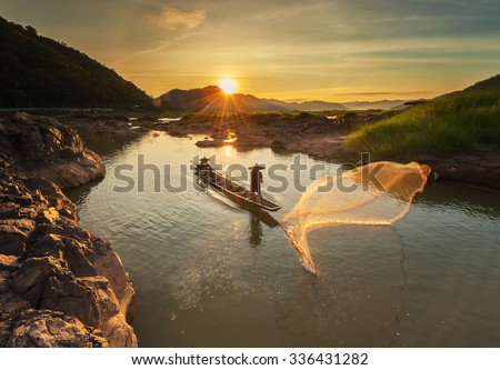 Fisherman of mekong river in action when fishing of sunrise