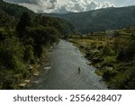 A fisherman navigates the river