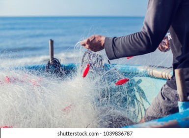 Fisherman On Boat With Net In Hands