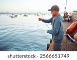 Fisherman preparing fishing rod with bait on a pier at sunset