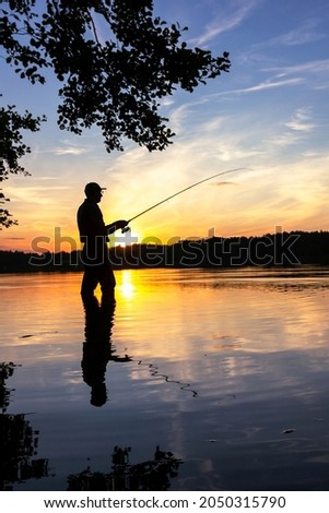 fisherman silhouette during summer sunset
