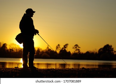 A fisherman silhouette fishing at sunset. Freshwater fishing - Powered by Shutterstock