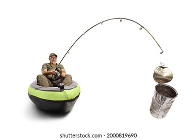 Fisherman sitting in a canoe and catching a tin can with a fishing rod isolated on white background