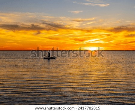 Fisherman in Small Boat at Sunset on The Laguna Madre,  Island Basin, Padre Island National Seashore, Corpus Christ, Texas, USA