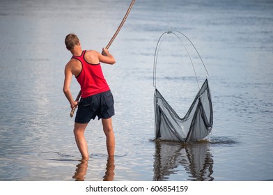 Fisherman throws a net on a stick