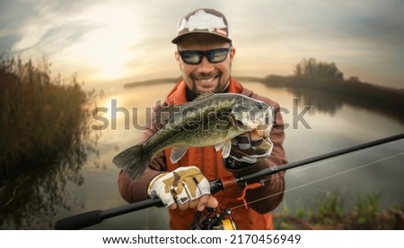 Fisherman and trophy Bass fish. Fishing background. 	
