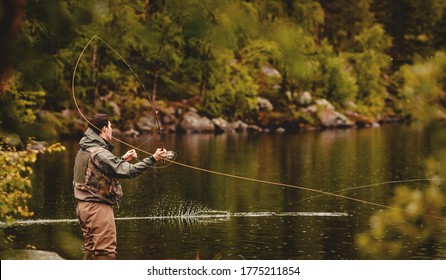 Fisherman using rod fly fishing in mountain river autumn splashing water. - Powered by Shutterstock