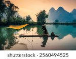 Fisherman villager with traditional fishing on bamboo raft over the river in misty morning, Surrounded by mountain in Phong Nam Valley, Cao Bang, Vietnam