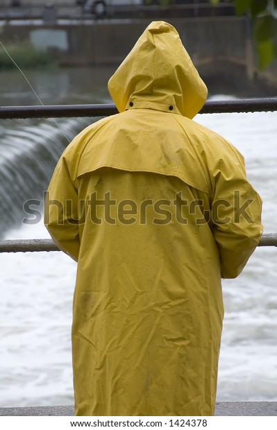 黄色いレインコートを着た漁師は ダムの上に白い川の水を見張る の写真素材 今すぐ編集