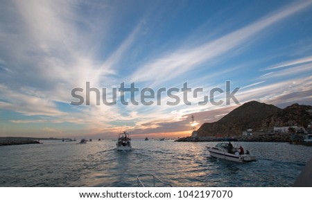 Fishermans sunrise view of fishing boats going out for the day past Lands End in Cabo San Lucas in Baja California Mexico BCS
