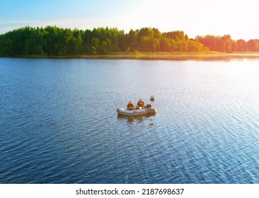 Fishermen boat on lake. Fishing for river fish from a motor boat using a fishing rod or spinning rod. Sports fishing on water. Rest in wild. Fishing boat with a fisherman on lake while catching fish.