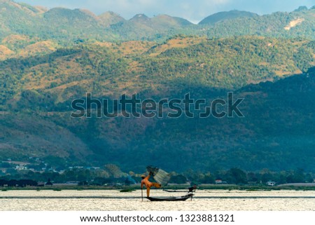 Fishermen holding a fishingnet at Inle Lake Myanmar with mountains in the background