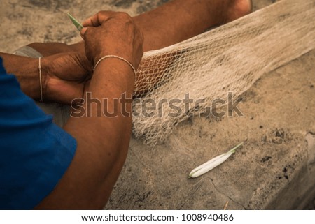 Fishermen knit net to catch sea animals