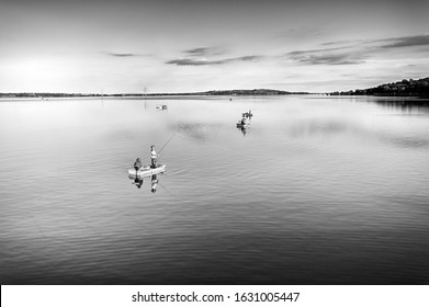Fishermen on boats on the Nové Mlýny reservoir. Black and white photo.