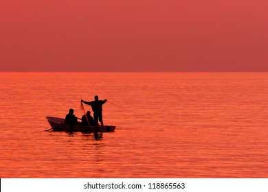 Fishermen setting fishing nets at sea.