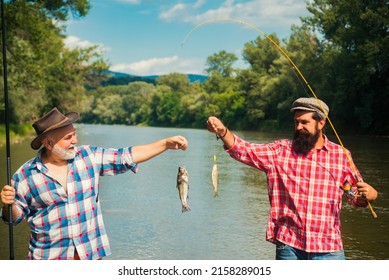 Fishermen successful catch fish. Fisher retirement. Retired businessman in suit with fishing rod. Male friendship. Granddad and drandson fishing. Catching trout fish.