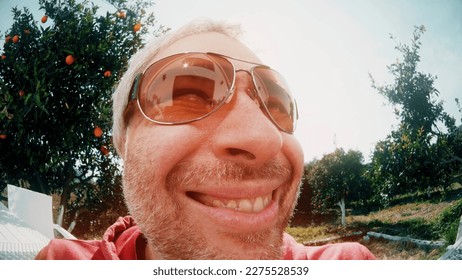 Fisheye lens portait of a happy smiling man wearing big sunglasses