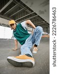 Fisheye of young Asian man dancing hip hop outdoors and wearing colorful street style clothes in urban setting