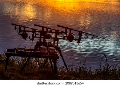 Fishing adventures, carp fishing. Angler, at sunset, is fishing with carpfishing technique. Camping on the shore of the lake.Carp Fishing Sunset
