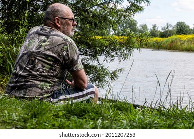 Fishing adventures, carp fishing. Angler is fishing with carp fishing technique in freshwater, scanning the water for signs of carp	