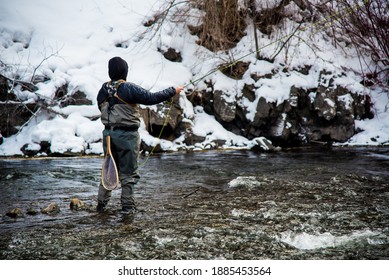 Fishing with artificial flies in the cold waters of winter.  Warm clothing and a passion for the sport is necessary in such frigid conditions. - Powered by Shutterstock