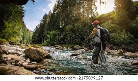 Fishing background. Fisherman catching trout on a river.	