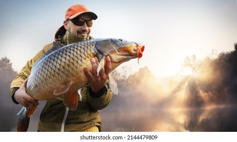 Fishing background. Young man hold big carp in his hands.	