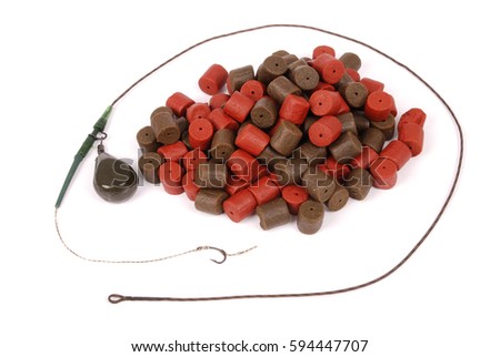 Fishing bait with hook and brown with red pre-drilled halibut pellets for carp fishing isolated on white background with soft shadow