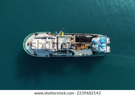 Fishing boat aerial view top from drone on sea surface. Fishing and seafood industry