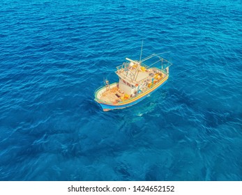 Fishing Boat In Blue Sea Water, Fishermen Set Nets For Fish. Aerial Top View.