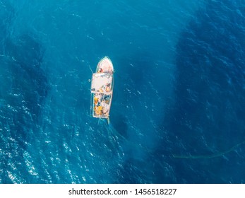 Fishing Boat In Blue Sea Water, Fishermen Set Nets For Fish. Aerial Top View.