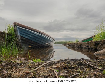 Fishing Boat By A Stone Pier, Calm Lake Water, Nobody, Cloudy Sky, Low Angle,